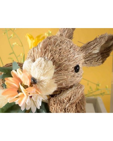 Décoration de Pâques: lapin en fibre naturelle allongé avec fleur -